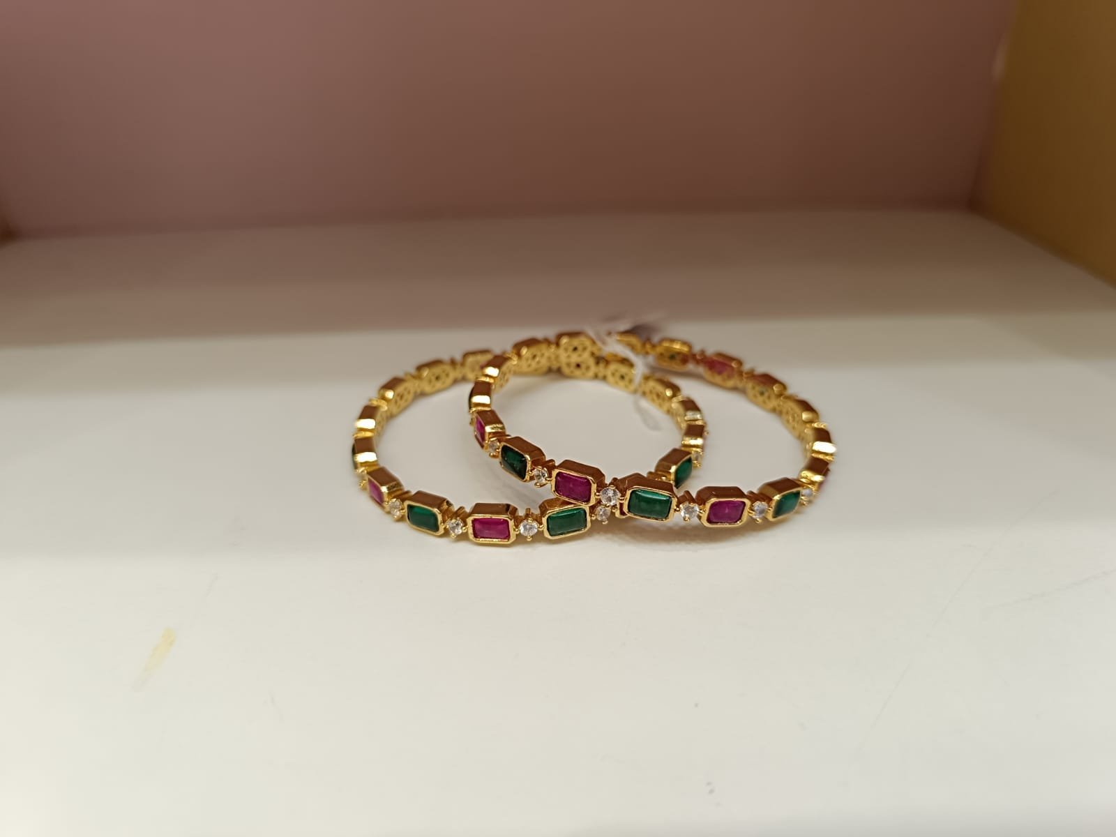 Red and green and white stones with gold polish bangle